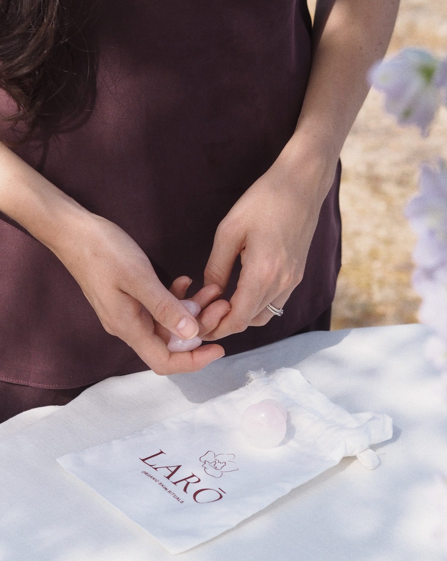 Gua sha y champiñones de cuarzo rosa sobre la bolsa de GAROA, joyas del tocador del taller